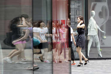 Pedestrians walk past a foreign-owned clothing store in Beijing's Sanlitun Area.