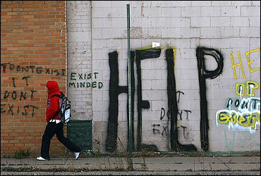 A pedestrian walks by graffiti on a downtown street in Detroit, Michigan.