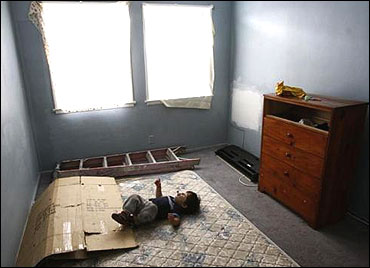 A two-year-old lies in the bedroom of the apartment their family is being evicted from, in Los Angeles.