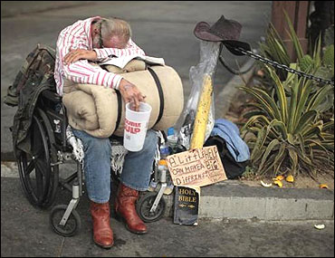 A homeless man begs for money in downtown Los Angeles.
