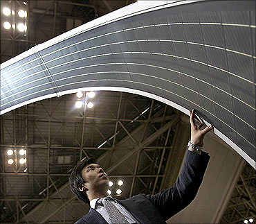A man touches a display of the Global Solar Energy's PowerFLEX BIPV flexible solar module in Tokyo.
