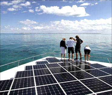People stand on the world's largest solar-powered boat in Cancun.