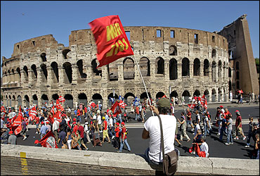 A demonstrator waves a flag in front of the Colosseum during a demonstration in Rome.