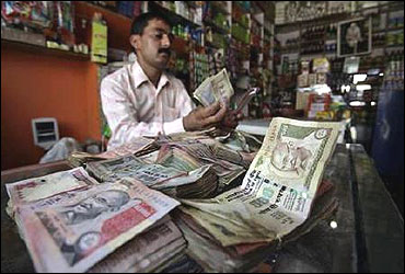 A shopkeeper counts rupee notes inside his shop in Jammu.