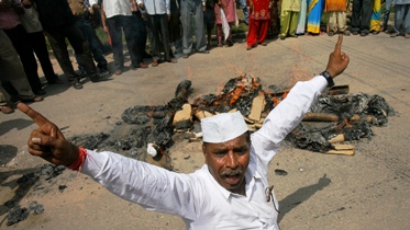 An activist shouts anti-government slogans after burning an effigy of the United Progressive Alliance government at a protest rally.