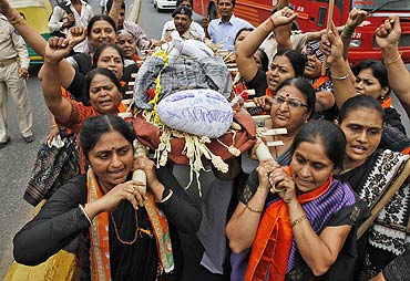 Supporters of Bharatiya Janata Party (BJP) carry an effigy depicting inflation during a mock funeral procession.