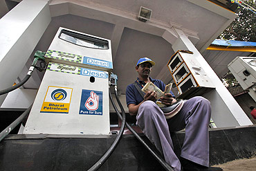 A worker counts Indian currency at a fuel station in Mumbai.