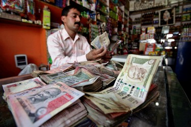 A shopkeeper counts Indian currency notes inside his shop in Jammu.