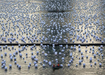 Workers arrange 'wishing spheres' as part of an art installation on the Singapore River.
