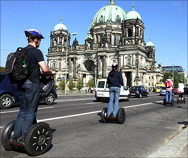Tourists take part in a guided tour through the city on segways as they pass the Berlin cathedral in Berlin.
