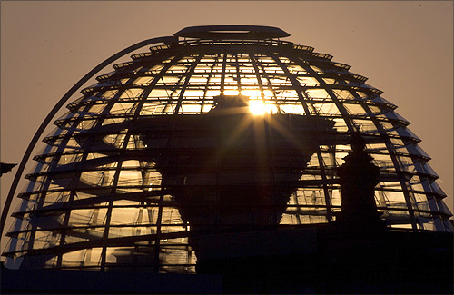 The sun rises behind the cupola of the Reichstag building, the seat of the German lower house of parliament, on a sunny cold day in Berlin.
