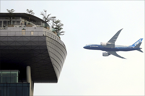 A Boeing 787-8 passenger jet flies near the skypark of the Marina Bay Sands hotel during a demonstration flight in Singapore.