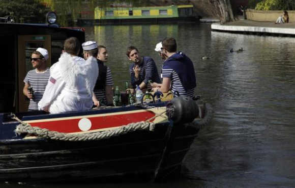 People sit in a boat at Little Venice on the Regent's Canal, in north London. The 14.5-kilometre Regent's Canal is one of the capital's best-kept secrets. Largely hidden behind buildings, the line sneaks its way through a rich collage of urban landscapes. Starting at the houseboats of Little Venice, it wends its way through Camden Lock and fashionable East London, and bypasses the site of the London 2012 Olympic Games before ending in Limehouse Basin.