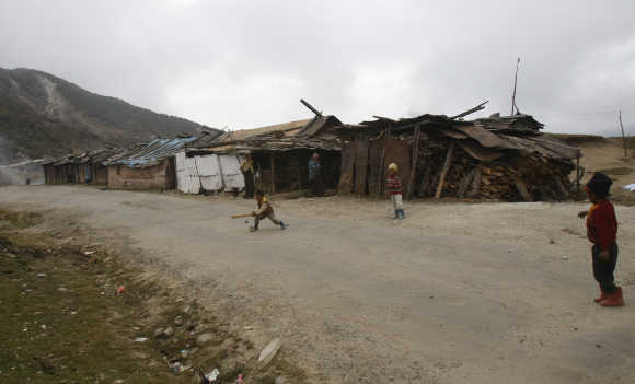 Children of labourers play cricket on a street near a stone crusher plant in Tawang in Arunachal Pradesh.