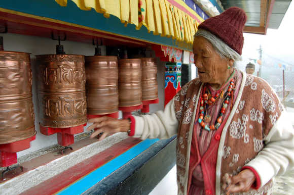 An elderly lady of the Manpa tribe spins prayer wheels at a monastery in Tawang in Arunachal Pradesh near the border with China.
