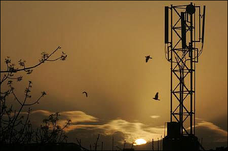 The sun rises behind a communications tower in New Delhi.