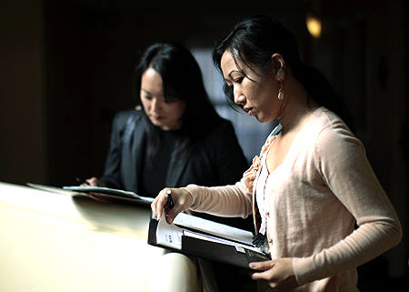 Job seekers Tiffany Tram, 30, (R) and Linda Kim, 30, wait for interviews at a job fair in a hotel in Los Angeles, California.
