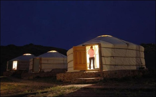 Men wrestle as a girl reacts at a tourist camp near the ruins of Ongi monastery in Mongolia's Dundgovi province.