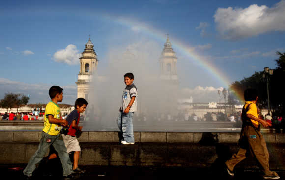 Children play near a fountain at the Parque Central in Guatemala City.