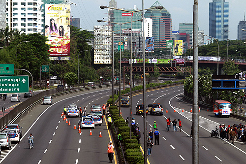 Policemen guard a toll road in Jakarta as students and workers protest against increasing fuel prices in Jakarta.