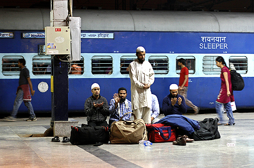 Passengers offer prayers before boarding a train at a railway station in New Delhi.