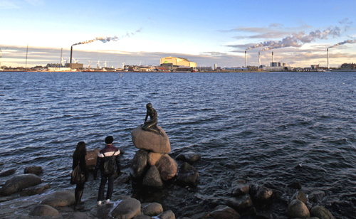 Tourists look at the sculpture of the Little Mermaid, inspired from a fairy tale written by Hans Christian Andersen, a famous landmark of Copenhagen.