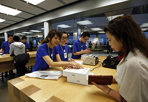 A woman (R) collects her new pre-ordered iPad outside an Apple store in Hong Kong.