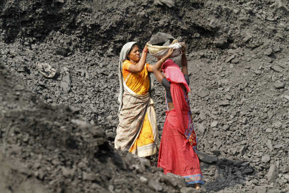 Labourers carry coal at a stockyard of an underground mine in the Mahanadi fields at Dera, near Talcher town, Orissa.
