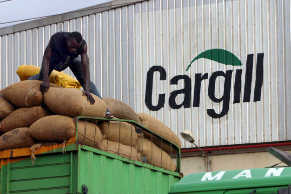 A man gathers bags of cocoa beans at the Cargill factory in Ivory Coast.