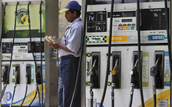 An employee counts money at a fuel station in Kolkata.