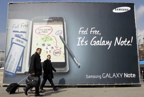 Visitors walks past a Samsung Galaxy tablet advertisement during the Mobile World Congress in Barcelona.