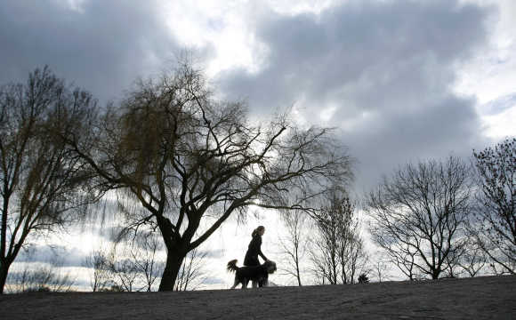 Woman walks with her dog on a dyke along the Weser river in Bremen.
