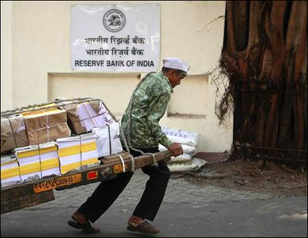 A man pulls a hand-drawn cart in front of the Reserve Bank of India building in Mumbai.