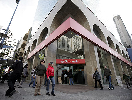 Residents walk infront of Santander branch in downtown Montevideo.