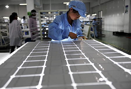 An employee works on a solar panel production line at a solar company workshop in Yongkang, Zhejiang province.