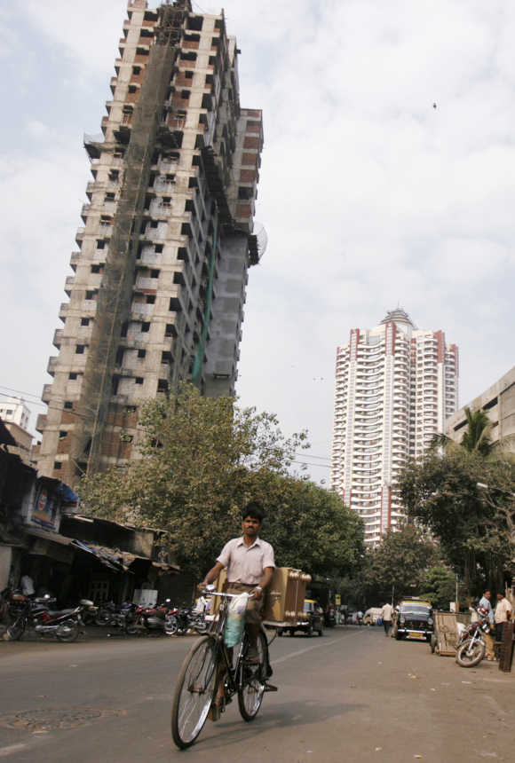 A man cycles past newly constructed buildings in Mumbai. Photo is for representation purposes only.