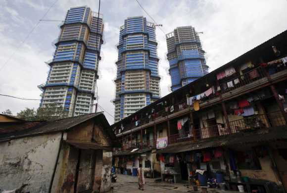 High-rise residential towers under construction are pictured behind an old residential building in Mumbai.