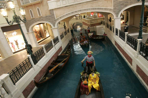 Newlywed couples from South Korea, Malaysia and Thailand sit on gondolas before the opening ceremony of the Venetian in Macau.