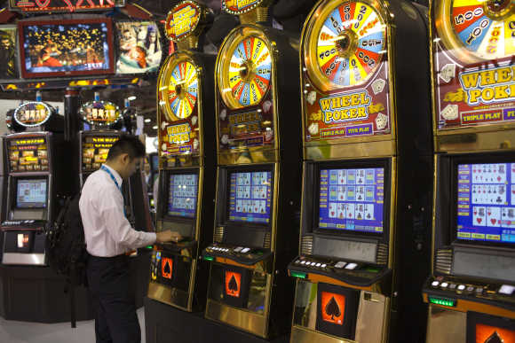 A man plays slot machines during the Global Gaming Expo Asia in Macau.