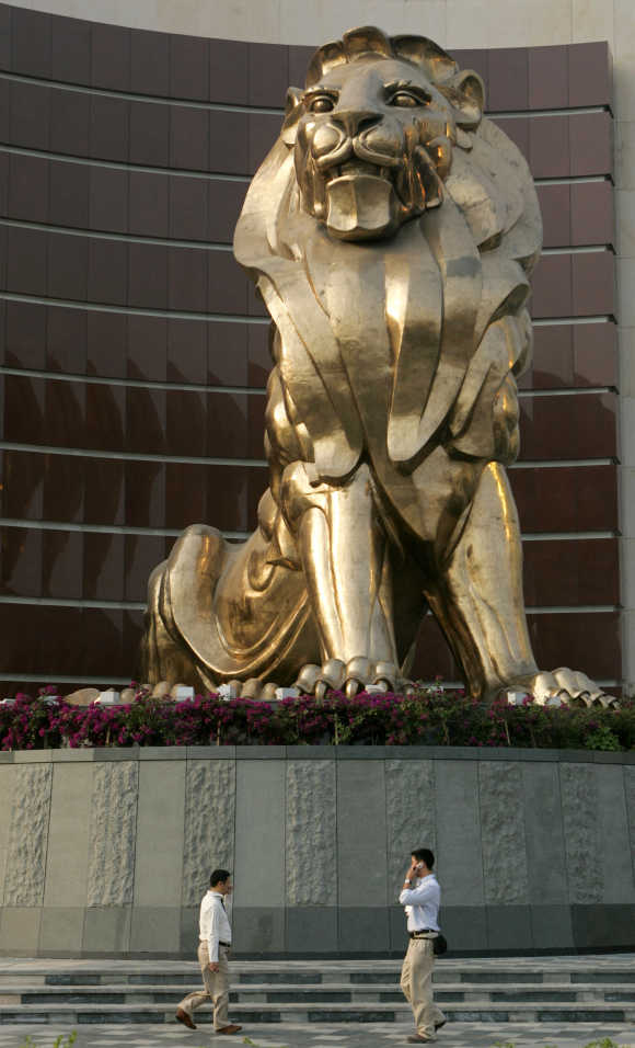People walk past a giant lion sculpture at the MGM Grand Macau hotel resort in Macau.