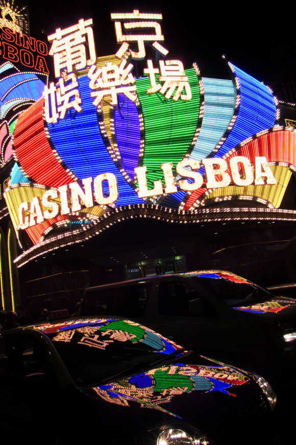 Lights from the Casino Lisboa are reflected on vehicles in Macau.