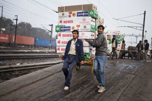 Workers move the morning delivery of flowers from a train at the Nizamuddin Railway Station.