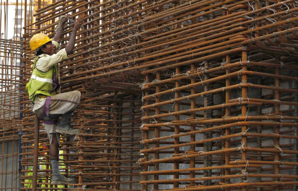 A worker climbs to fasten iron rods together at the construction site in Mumbai. Photo is for representation purpose only.