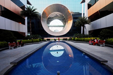 Employees walk in front of a building dubbed the 'washing machine', a well-known landmark built by Infosys, Bengaluru.