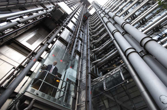 Architect Richard Rogers poses inside an elevator in the Lloyd's building in London. Rogers, who designed the building for the insurance company, was marking its 25th anniversary.