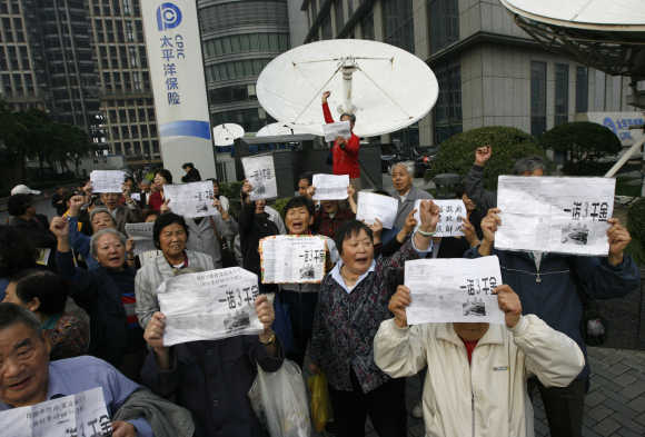 People protest in front of the China Pacific Insurance Company building in Shanghai.