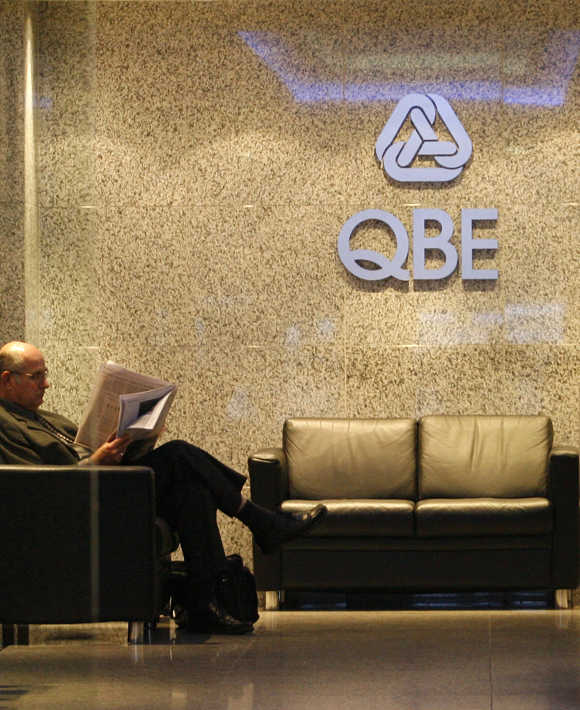 A man reads the newspaper at the QBE Insurance Group headquarters in central Sydney.