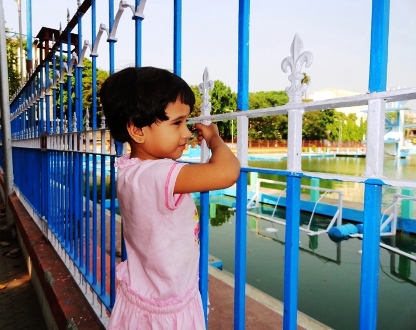 A child peeps through the railings surrounding College Square pool in north Kolkata.