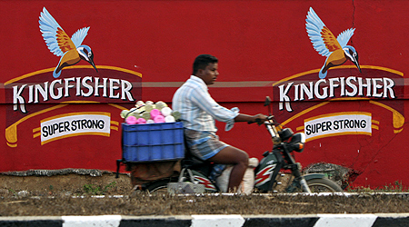 A man on a motorbike rides past the factory of United Breweries Ltd (UB) that manufactures Kingfisher beer in Thiruvalluar district, Tamil Nadu.
