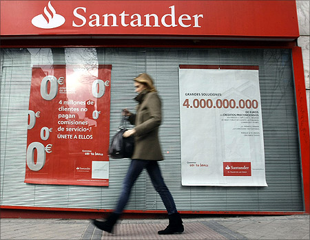 A woman walks past a Santander bank branch in central Madrid.